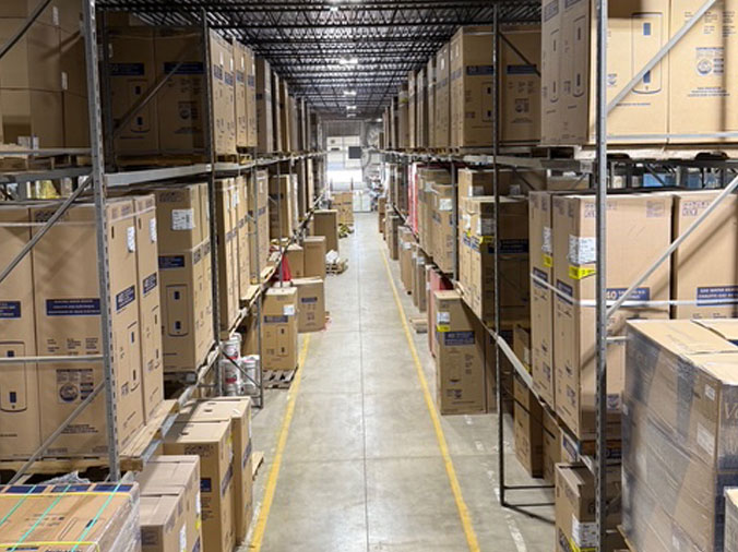 Shelves stocked with new water heaters in boxes in the plumbing supply warehouse at McDonald Plumbing Supply in Des Moines Iowa